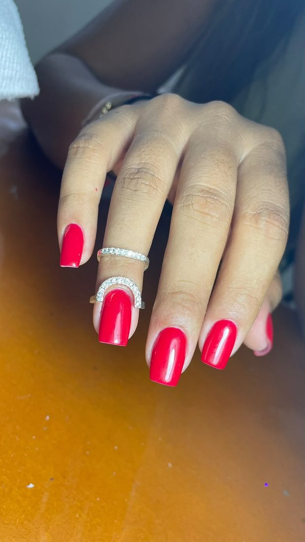 Mano con uñas cuadradas en rojo intenso